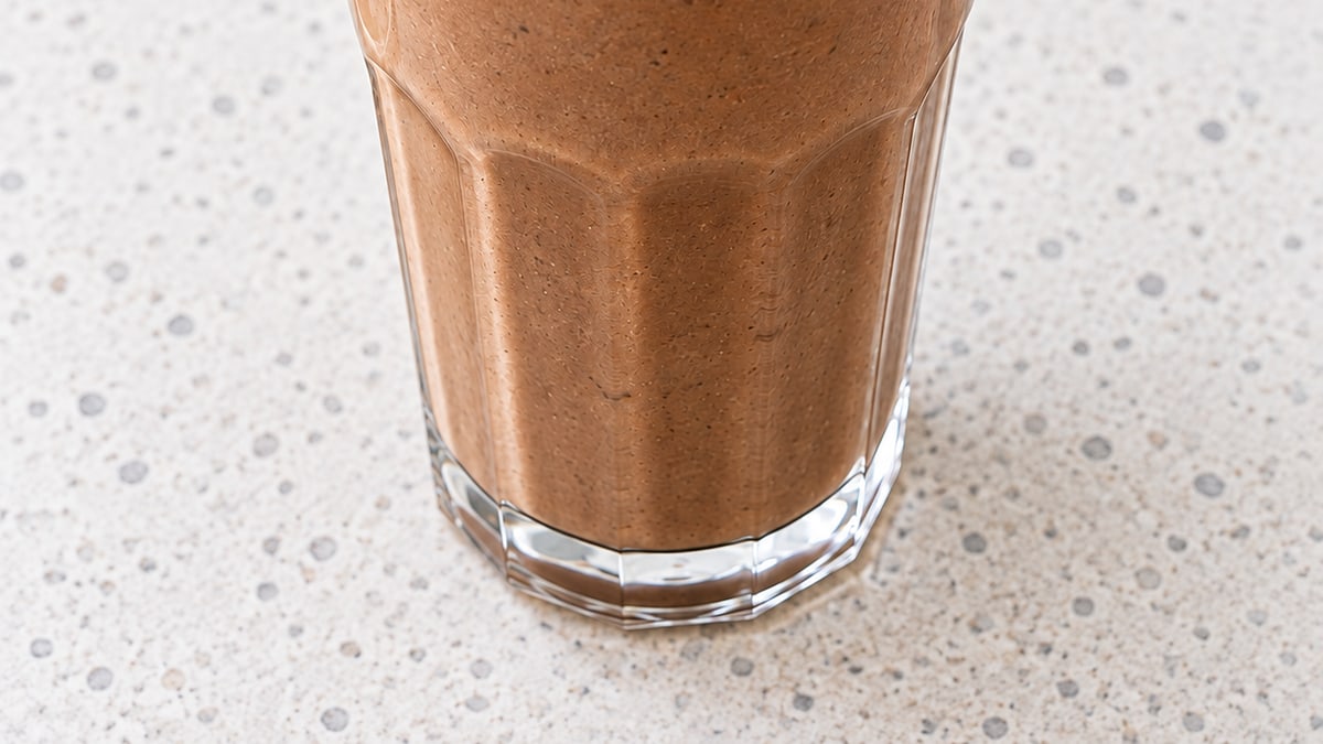 Proteinsmoothie med chokolade og peanutbutter. AI-genereret serveringsforslag.