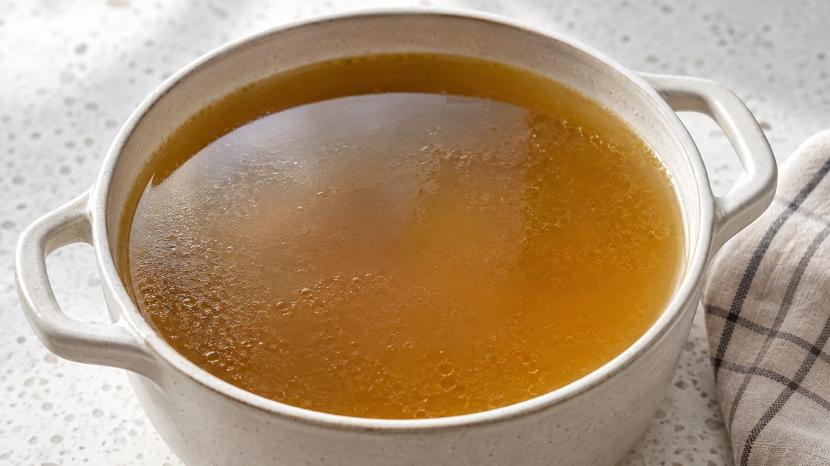 Grøntsagsbouillon. AI-genereret serveringsforslag.